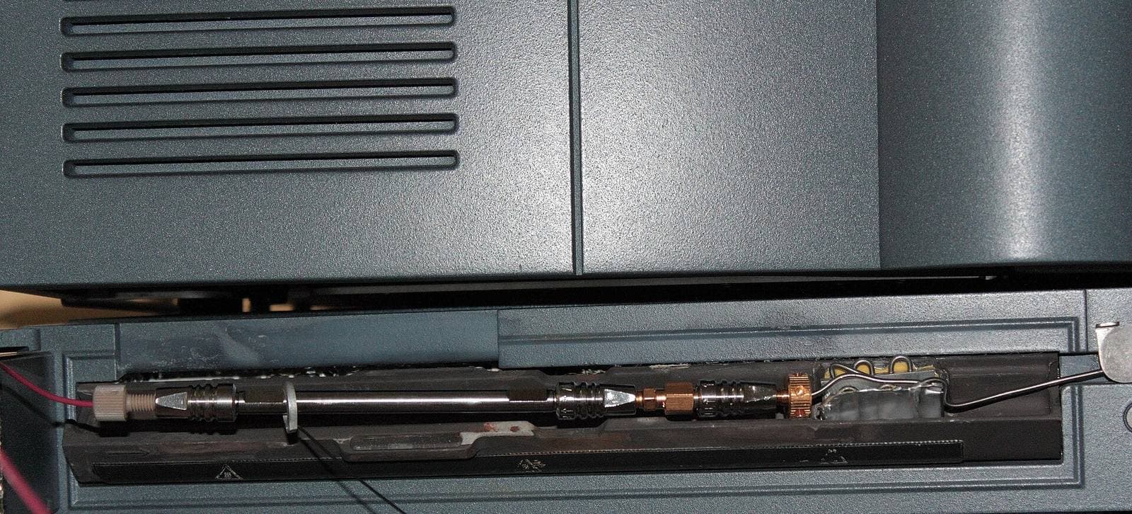 Close-up of a liquid chromatography column with a guard column fitted inside an instrument column oven