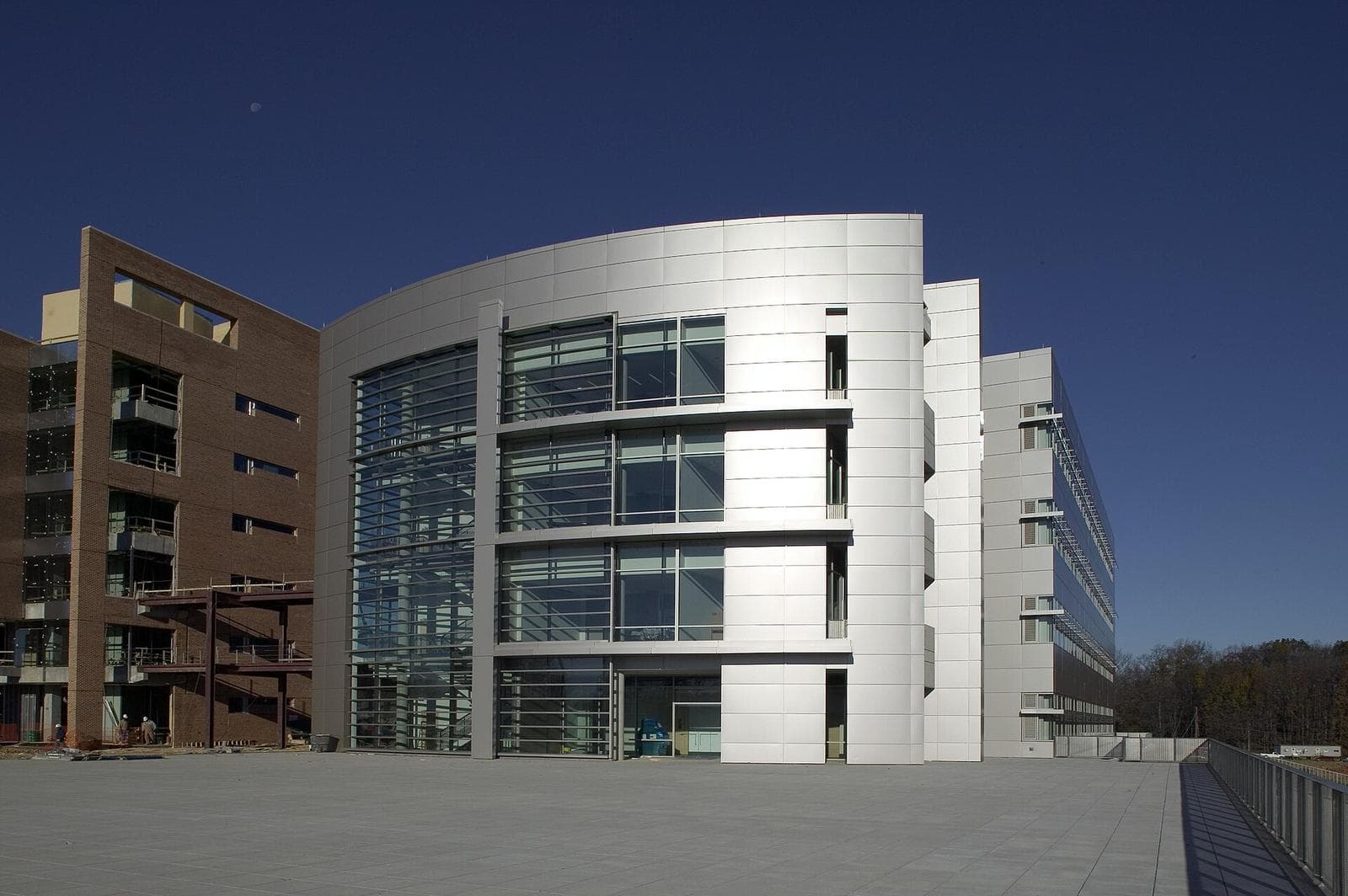 Exterior of a modern glass and metal laboratory building on the FDA White Oak campus against a deep blue evening sky