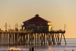 Huntington Beach Pier and the red-roofed building at its end in late afternoon light
