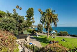 Lawn, palms and walking path at Heisler Park on the bluff above the ocean in Laguna Beach